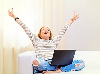 a girl feeling happy and free in front of the laptop